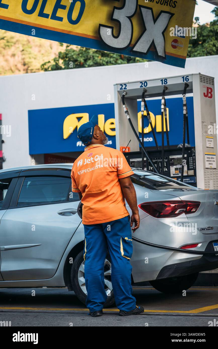 Mitarbeiter an der Tankstelle betankt das Auto eines Kunden in Brasilien Stockfoto