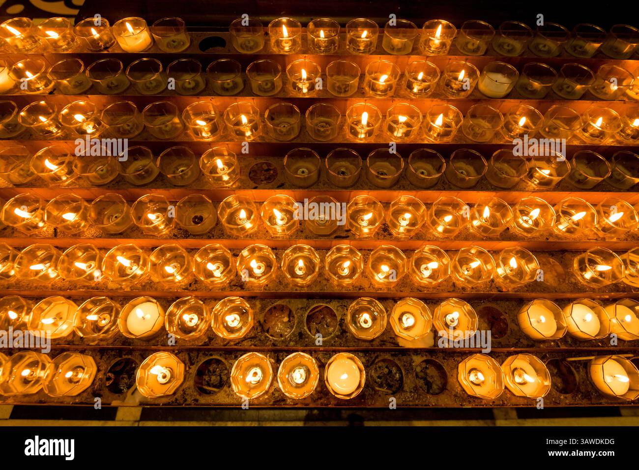 In Kirchen werden Kerzen vor einer Statue oder einem heiligen Bild von Jesus oder einem heiligen angezündet. Das Licht steht für Gebete, die im Glauben angeboten werden - das Licht Gottes. Kerzen spielen seit Jahrhunderten in verschiedenen Kulturen weltweit eine wichtige Rolle. Ein Symbol des Lichts, des Lebens, der Reinigung und der Hoffnung. Mailänder Kathedrale - Metropolitan Cathedral - Basilika der Geburt der Heiligen Maria, Mailand, Italien. Stockfoto