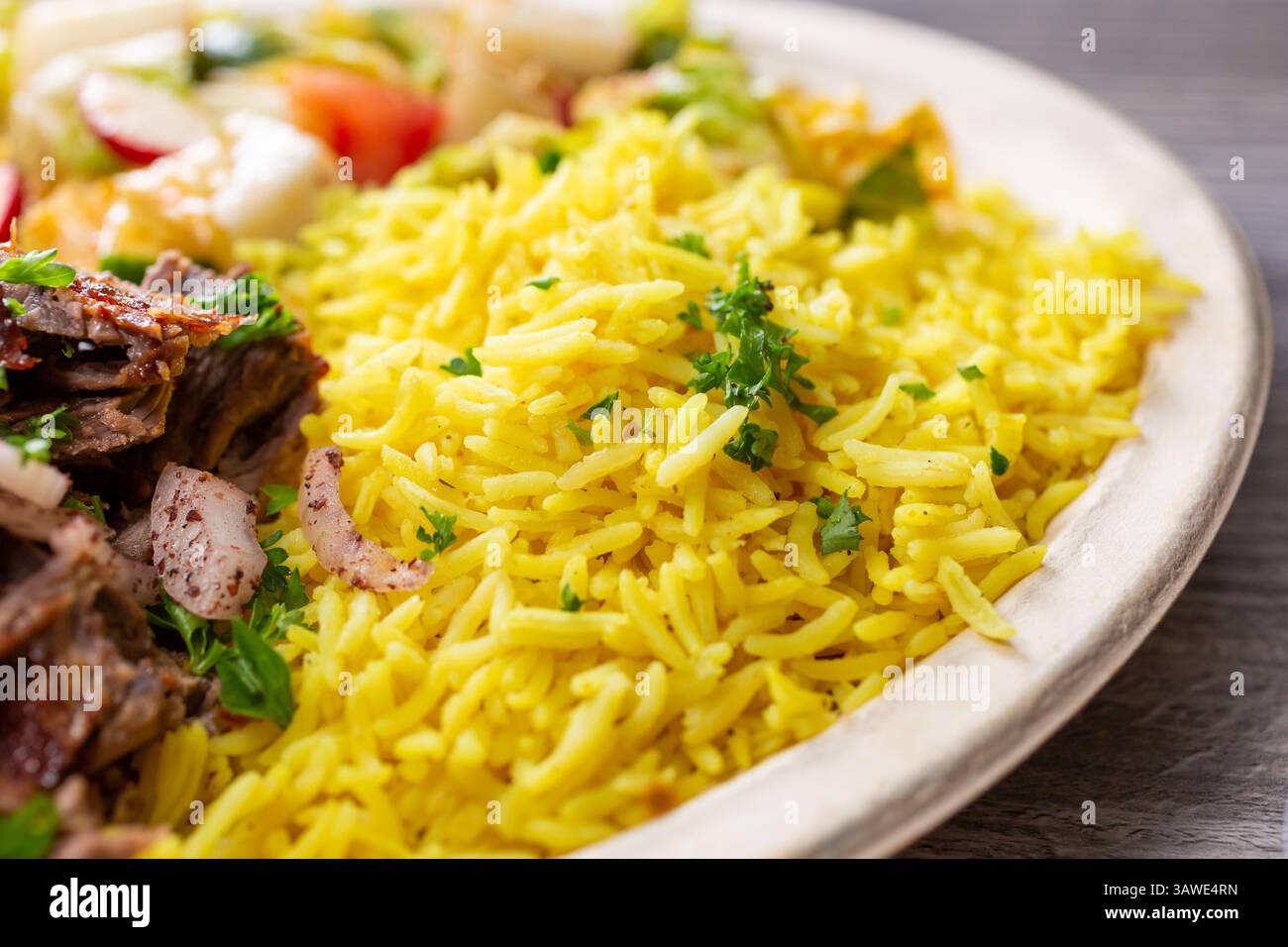 Eine Nahaufnahme einer mediterranen Platte mit gelbem Kurkuma-Reis. Stockfoto