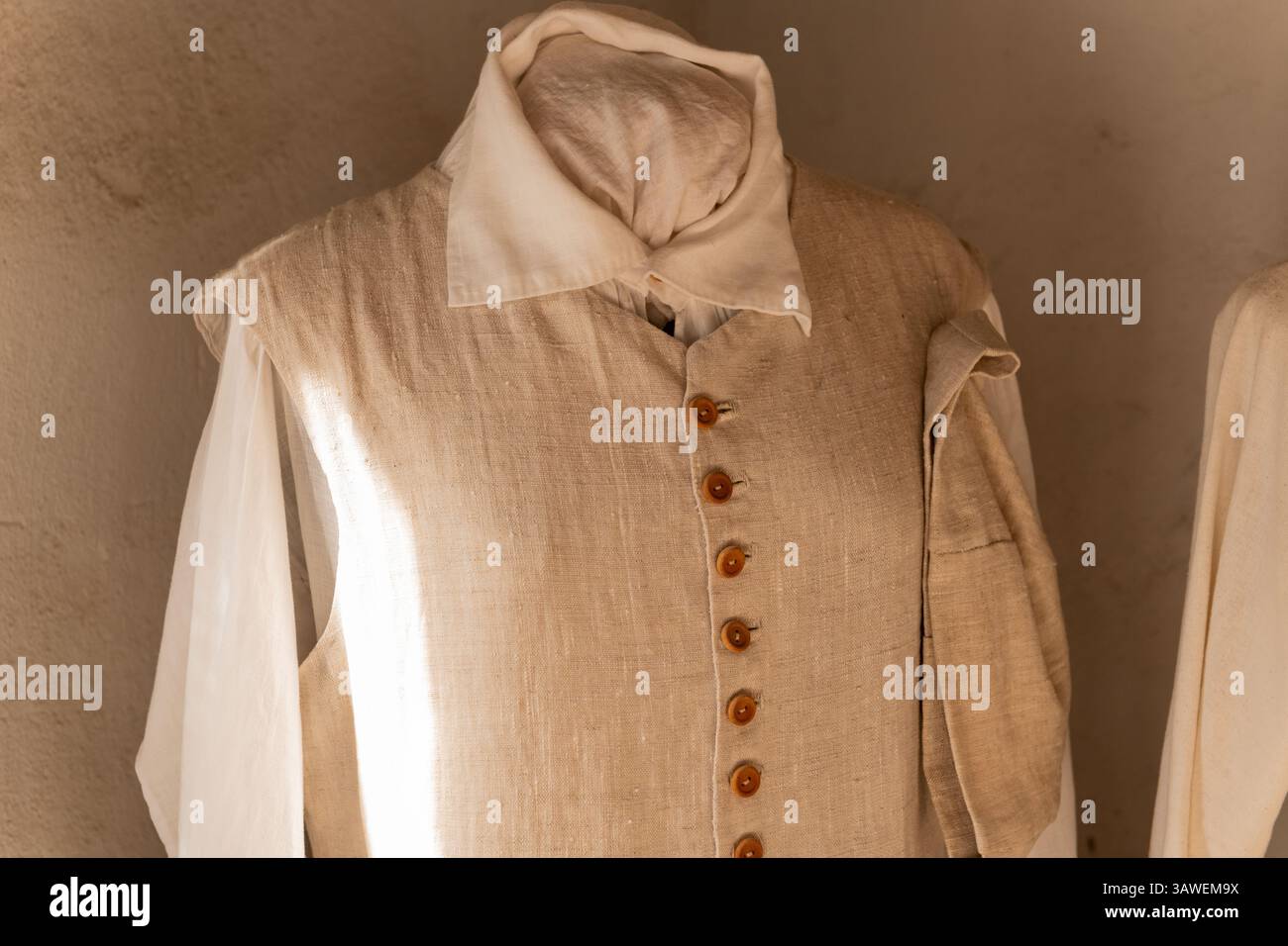 Eine traditionelle Leinenweste im Kolonialstil mit Holzknöpfen, die drinnen auf der Middleton Place Plantation in Charleston, SC, ausgestellt werden. Stockfoto
