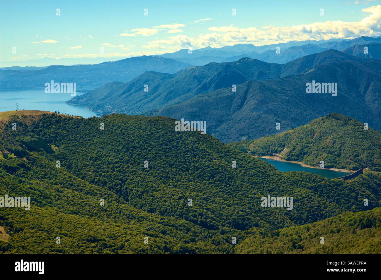 Unten rechts ist der See Delio in der Provinz Varese, Lombardei, Italien. Auf einer Höhe von 930 m beträgt die Fläche etwa 30 ha (74 Acres). Er dient als oberer Stausee für das Pumpspeicher-Wasserkraftwerk Roncovalgrande. Stockfoto