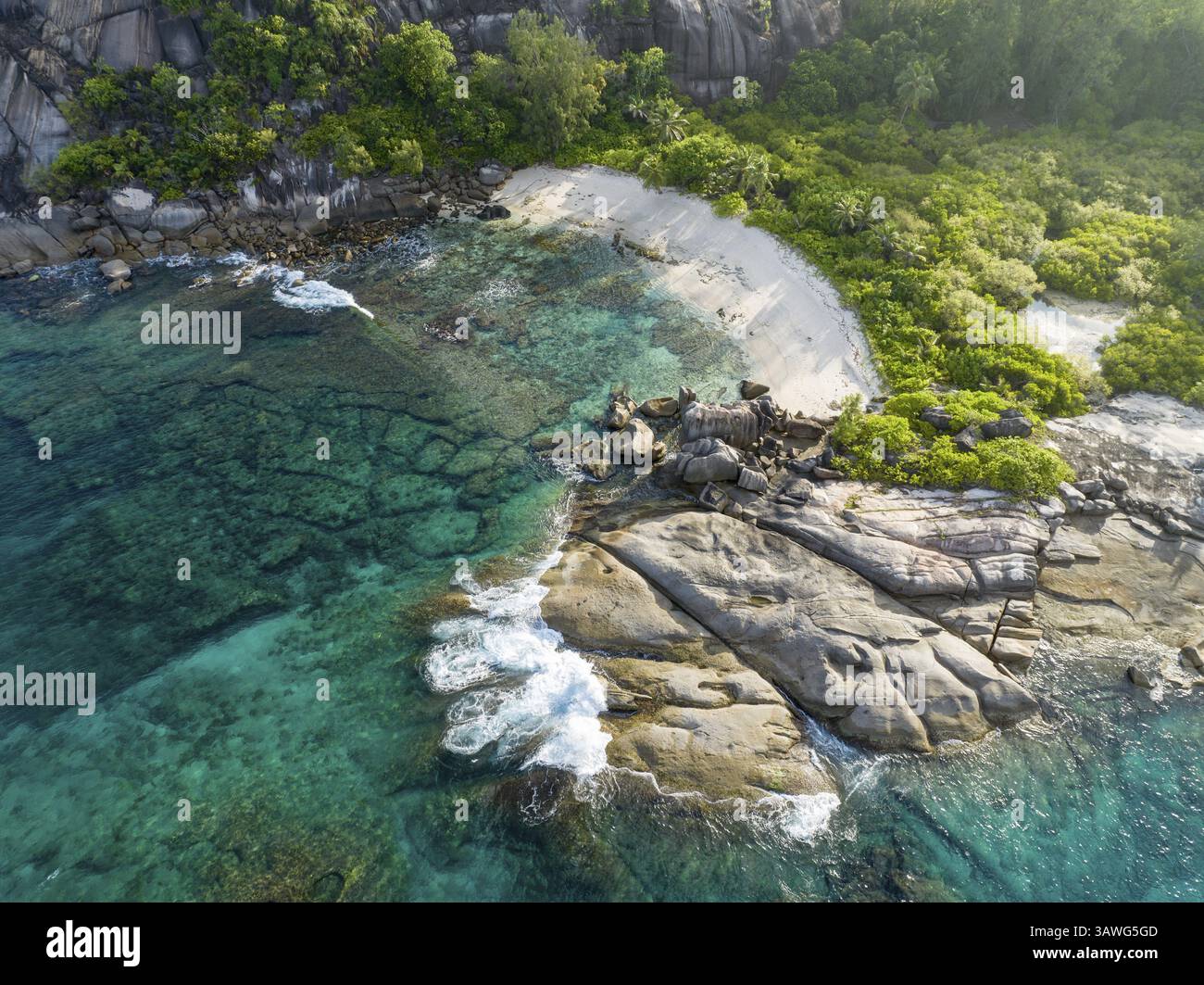 Küste mit Wellen, großen Felsen und tropischer Vegetation auf türkisfarbenem Wasser, Blick aus der Vogelperspektive, seychellen, Mahe, Port Glaud und Therese Island Stockfoto