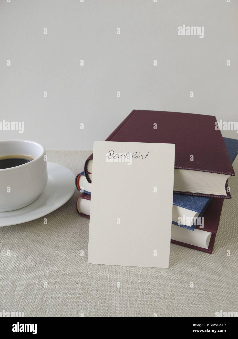 Ein Stapel Bücher, eine Liste mit Büchern und eine Tasse Stockfoto