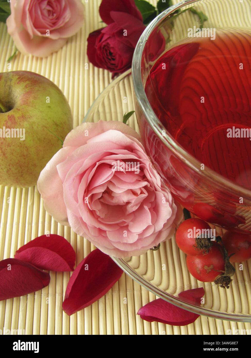 Obsttee mit Apfel, Hagebutte und Rosenblüten Stockfoto