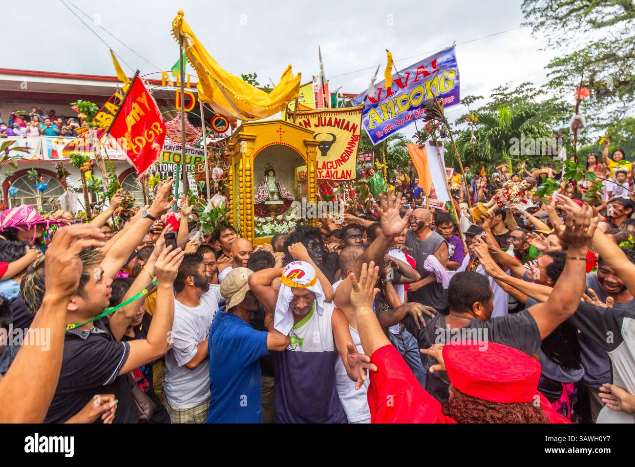 Während des Ibajay Ati-Ati Festivals in Aklan, Philippinen, tragen und verehren die Besucher ein Bild des Sto Niño auf ihren Schultern Stockfoto