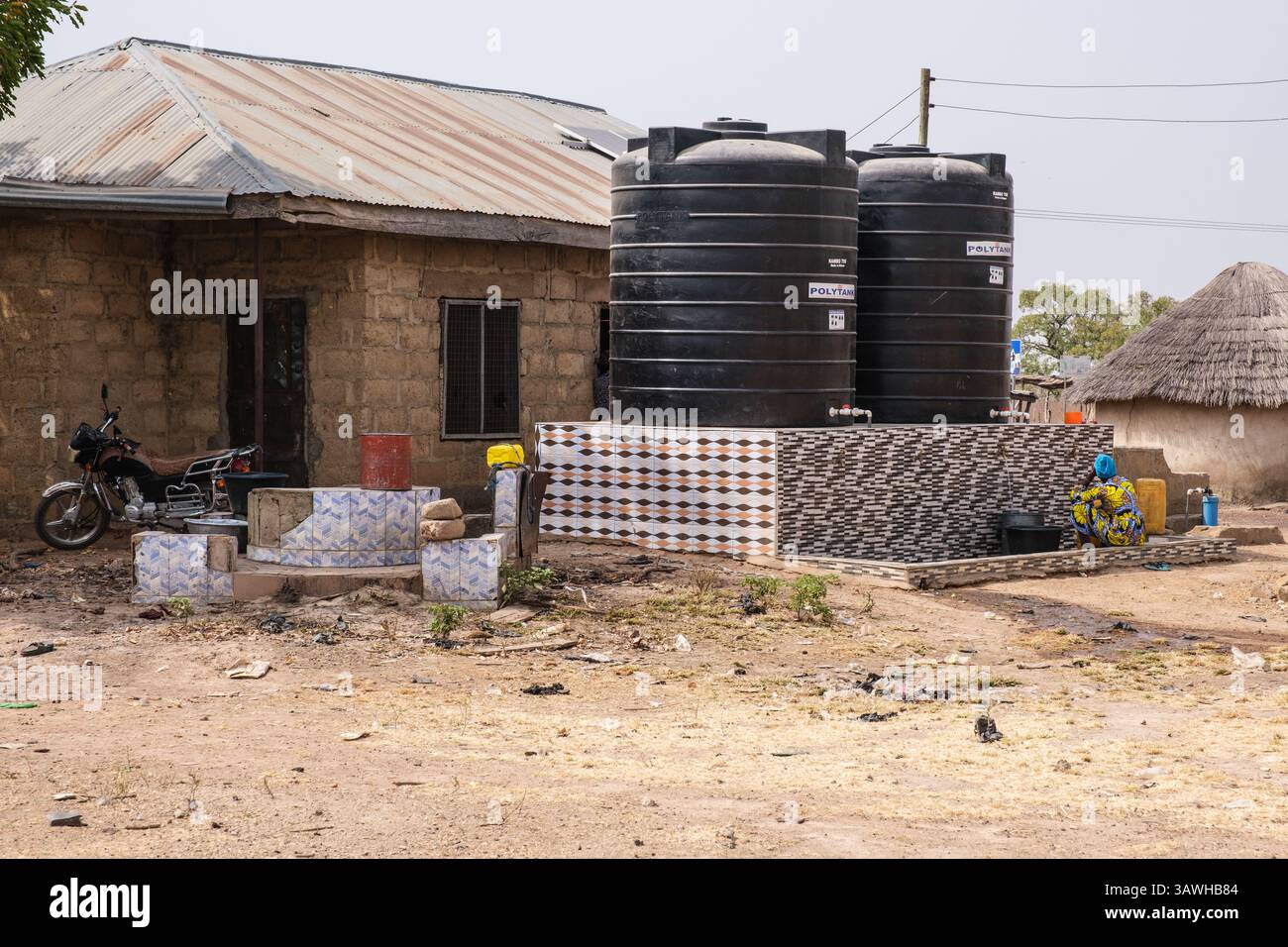 Ghana, Fufolso. Frau, die in den Wasserspeicher des öffentlichen Dorfes wartet, damit das Wasserschiff gefüllt wird. Stockfoto
