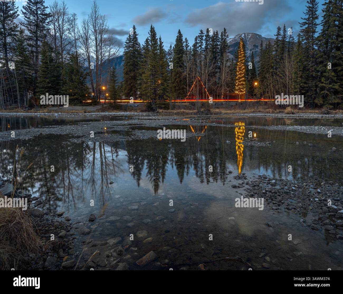 Weihnachten und Ampeln spiegeln sich im Spring Creek in Canmore, Alberta, Kanada Stockfoto