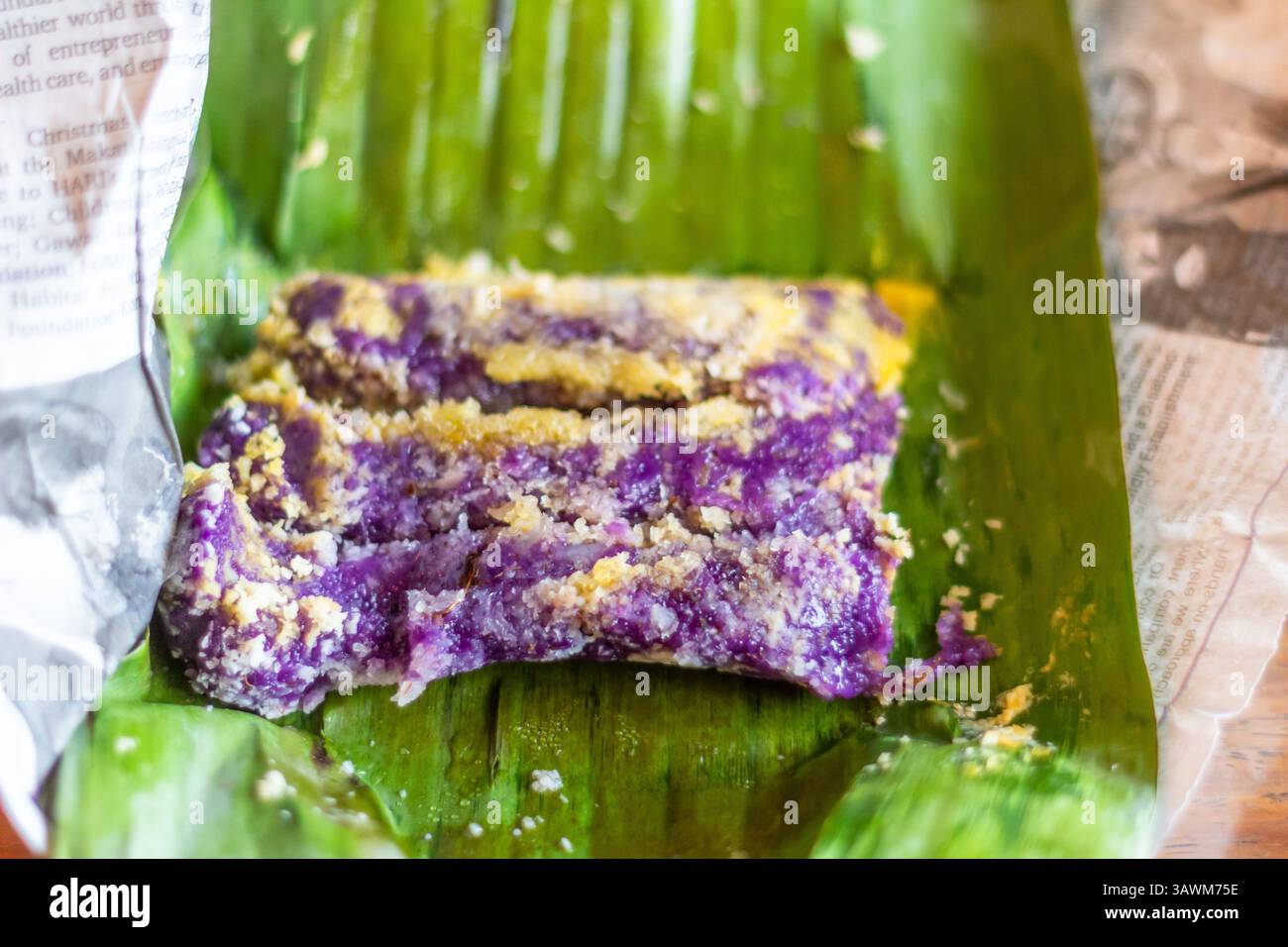 Puto Bumbong serviert auf einem Bananenblatt und garniert mit Kokosstreifen, braunem Zucker und Margarine in Malabon, Philippinen, einem beliebten philippinischen urlaubsort Stockfoto