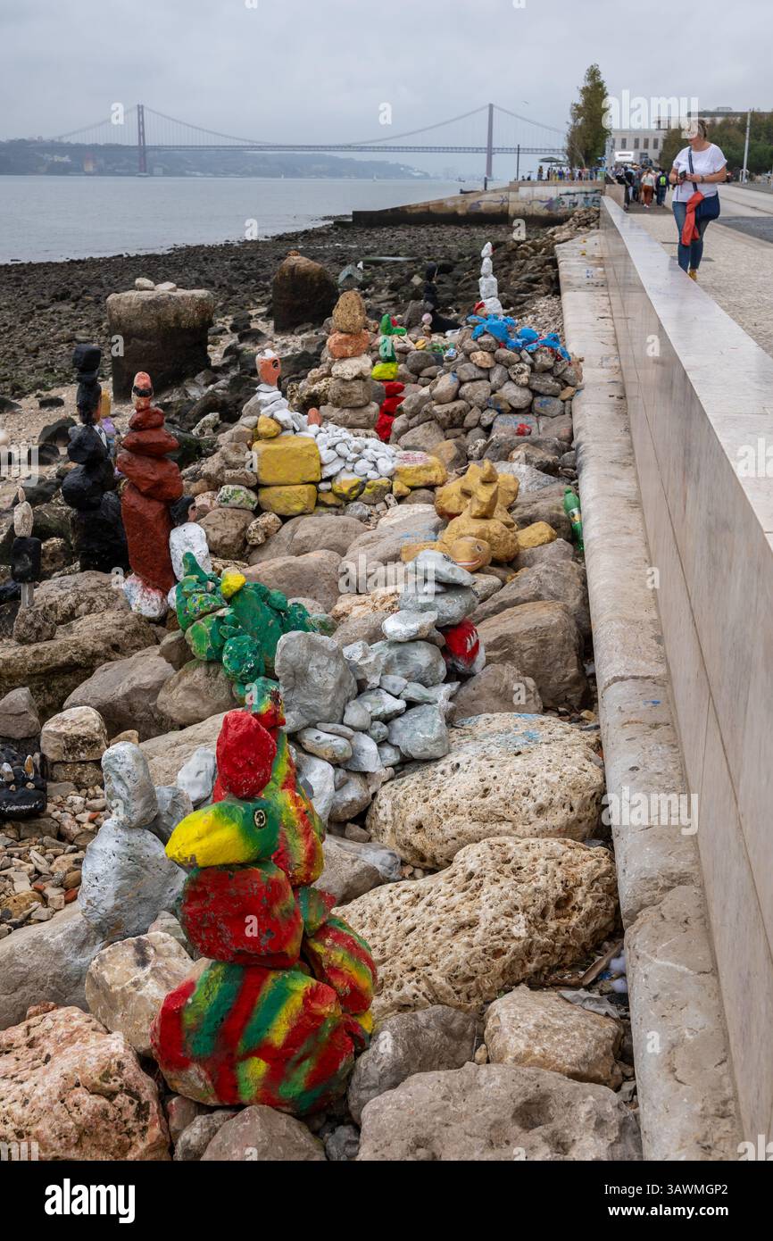 Gemalte Steinskulpturen, einfache, rudimentäre Kunst am Kieselstrand an der Mündung des Flusses Tejo in Lissabon, Portugal. Stockfoto