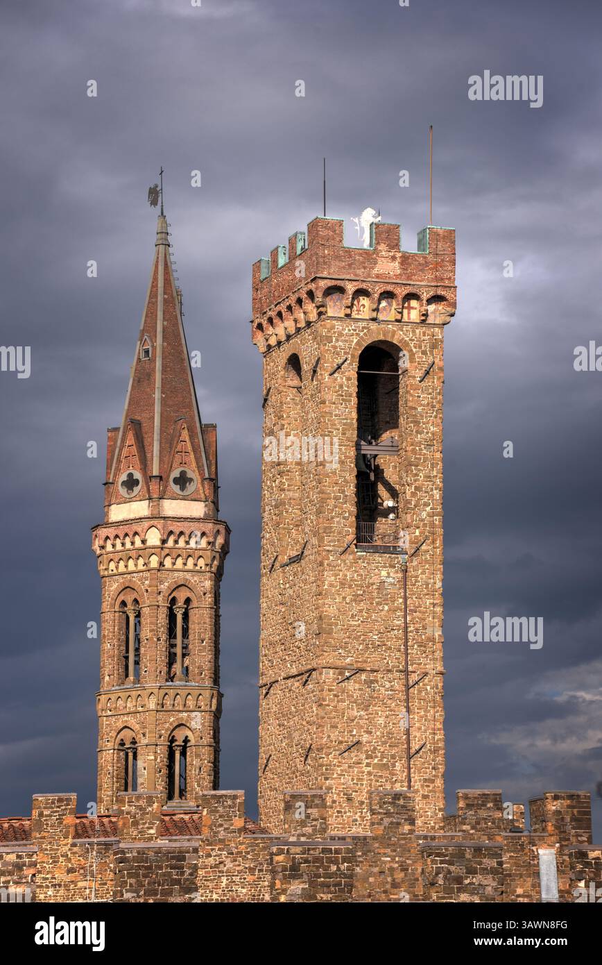 Mittelalterliche Türme erheben sich vor einem dramatischen bewölkten Himmel und zeigen den architektonischen Charme von Florenz, Italien. Stockfoto