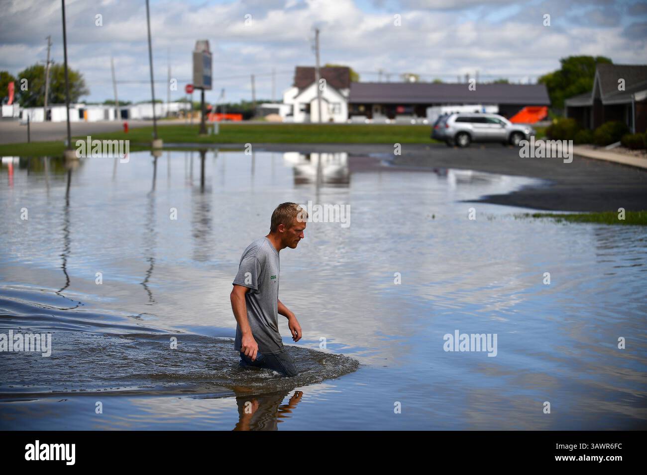 11. August 2016 - Willmar, MN, USA - Chad Koosman aus Willmar, Minn., wate durch das Wasser Donnerstag, 11. August 2016, um eine Vorstellung davon zu bekommen, wie tief es auf dem Parkplatz hinter einem seiner Appartementhäuser war. Koosman verbrachte die Nacht damit, das Wasser zu bekämpfen und den Mietern zu helfen, ihre Sachen zu verlagern. (Bild: © Aaron Lavinsky/TNS via ZUMA Wire) Stockfoto