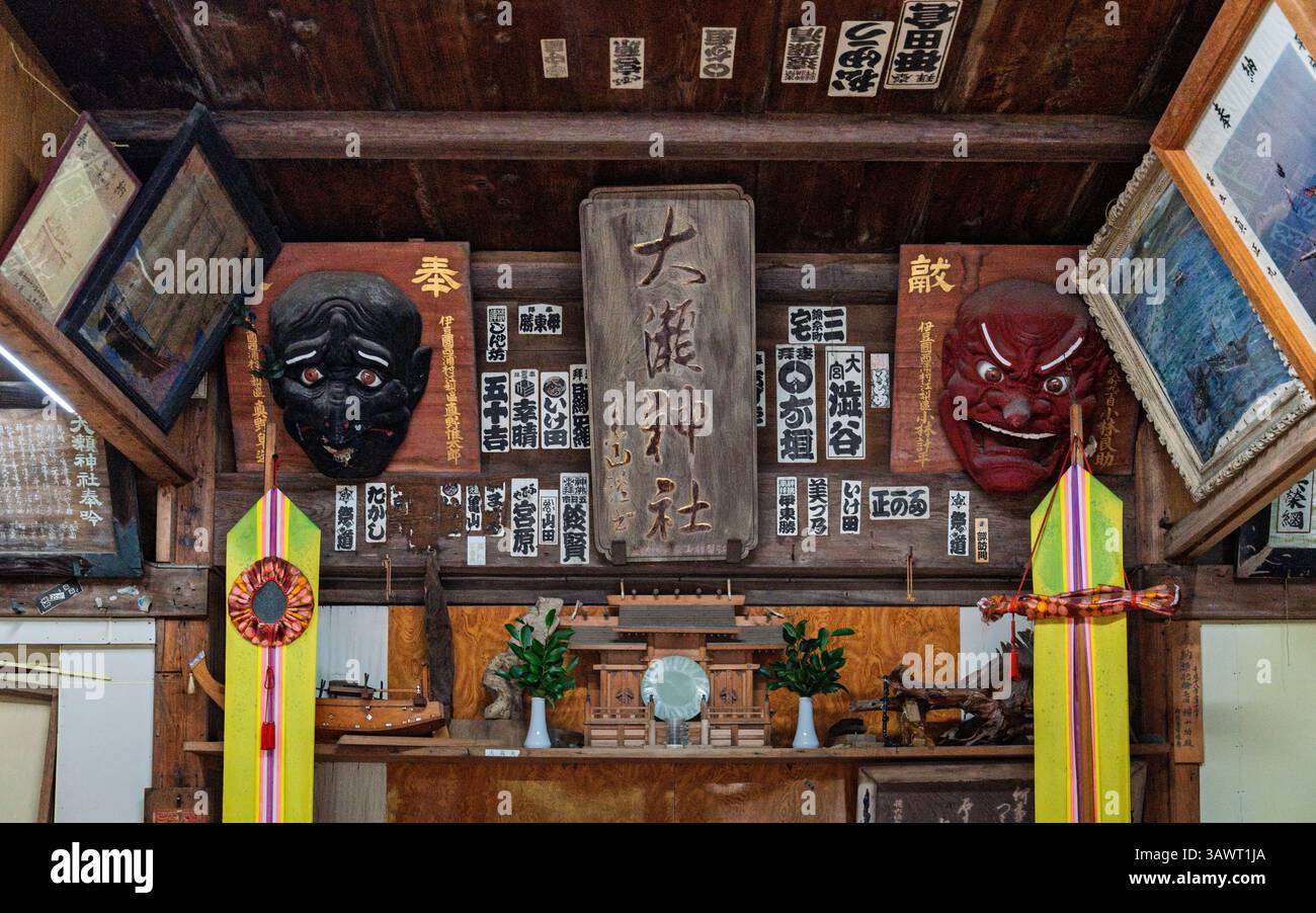 Das Innere der Emaden Hall am OSE-Schrein am Kap OSE zeigt rituelle Artefakte, darunter Fotos, Gemälde und Miniatur-Skulpturen von Fischerbooten Stockfoto