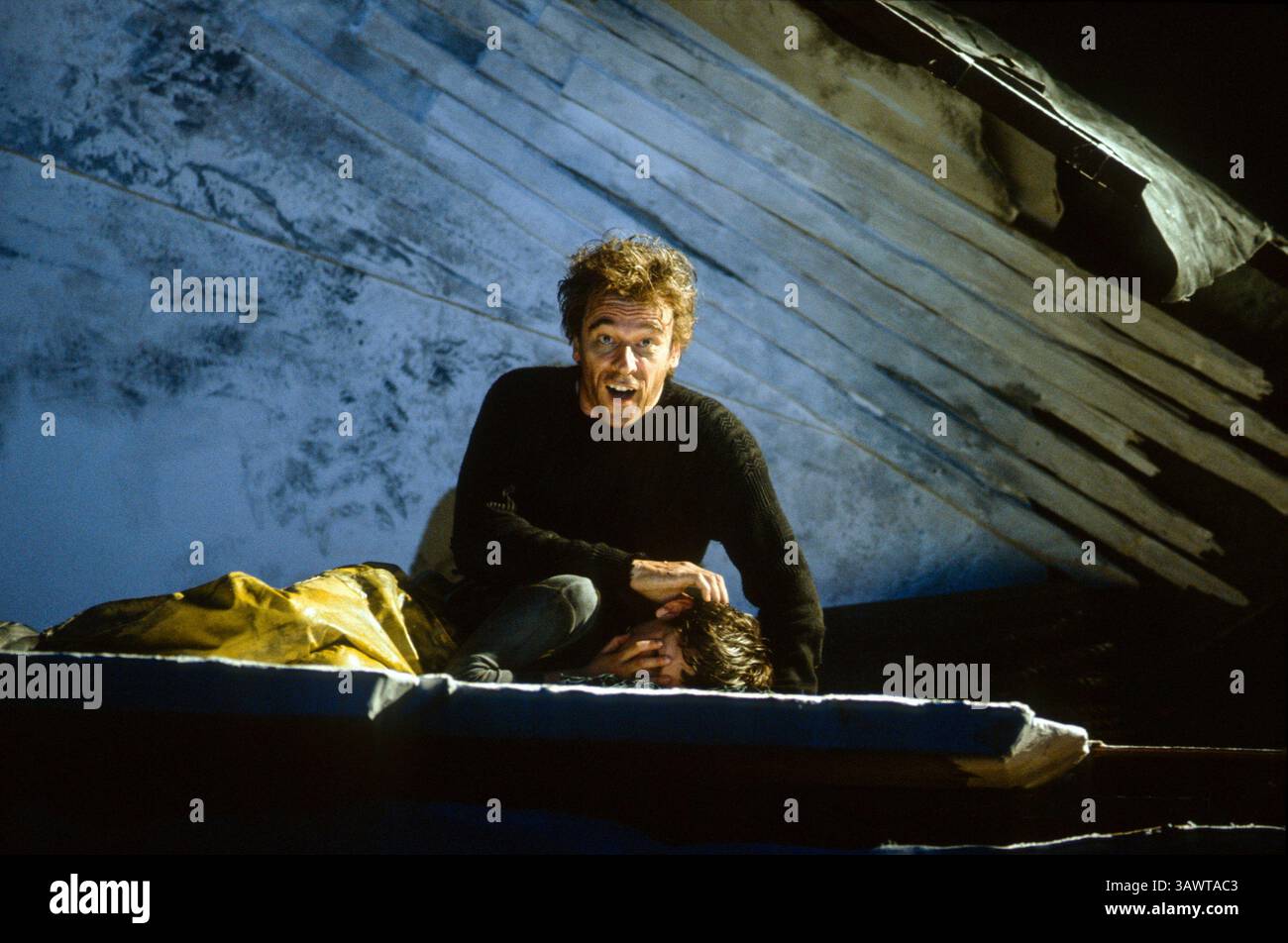 Mit dem Körper seines Lehrlings: Philip Langridge (Peter Grimes) in PETER GRIMES an der English National Opera (ENO), London Coliseum, London WC2 17/04/1991 Musik: Benjamin Britten Libretto: Montagu Slater Dirigent: David Atherton Bühnenbild: Hildegard Bechtler Kostüme: Nicky Gillibrand Beleuchtung: Jean Kalman Regisseur: Tim Albery Stockfoto