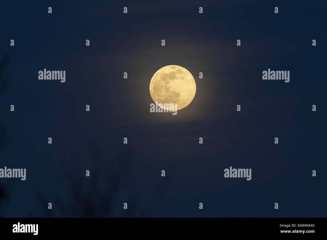 Vollmond mit weichem Halo über Montegallo, Italien, aufgenommen mit einem 200-600-mm-Objektiv von Sony. Klare Details und tiefblauer Himmel in einer Winternacht Stockfoto