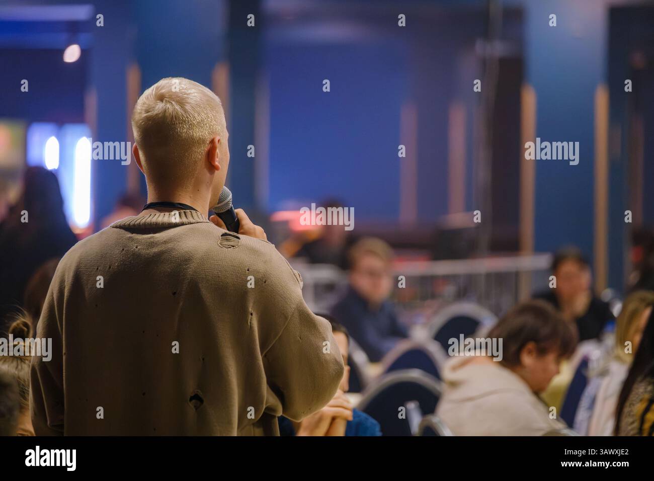 Der Sprecher spricht das Publikum auf einer professionellen oder informativen Versammlung in zeitgenössischem Ambiente an Stockfoto
