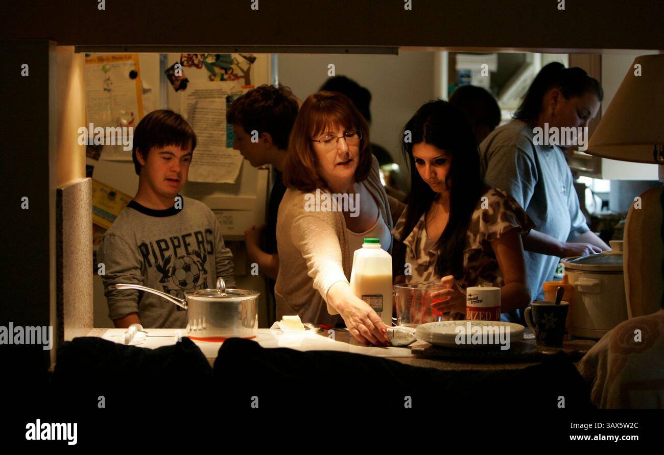 Februar 2010 - Spring Valley, CA, USA - 22/2010 Spring Valley, CA. USA MARCIA JONES hilft ihren Kindern IAN, 12, links, und ZANIST ALI-JONES, 17 (cq). finde heraus, wie man Kartoffelpüree in Pulverform für die Zubereitung des Abendessens mischt. Der Fokus dieser Geschichte liegt auf der Familie JONES und ihrem Adoptivsohn RUBEN, 8 Jahre alt, der Down-Syndrom und Autismus hat. RUBEN erhält therapeutische Leistungen vom Sam and Rose Stein Education Center in Vista Hill, und durch Kürzungen des Staatshaushalts wurde die Zeit, die er im Stein Center in Anspruch nehmen kann, reduziert. Die Familie JONES, die Eltern MARCIA und DEAN, und ihre Familie Stockfoto