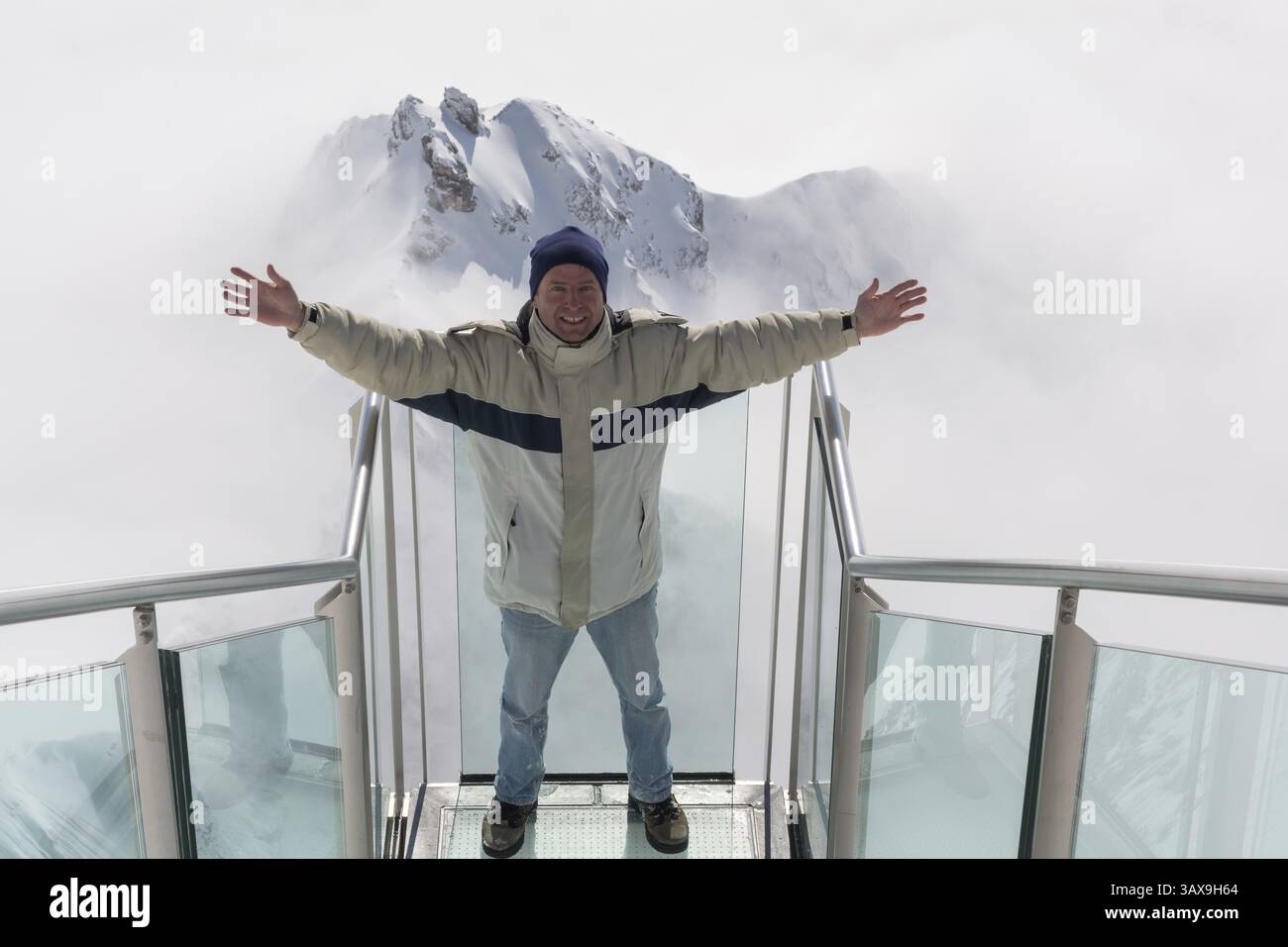 Ein Mann steht glücklich auf der Treppe ins Nirgendwo im Dachsteingebirge Stockfoto