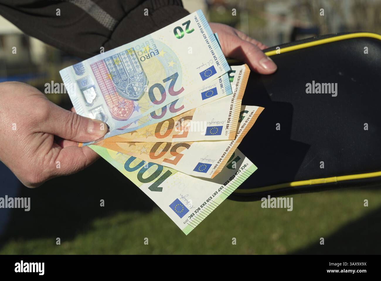 Person mit Papiergeld und Geldbörse in der Hand - Geschäftswährung Stockfoto