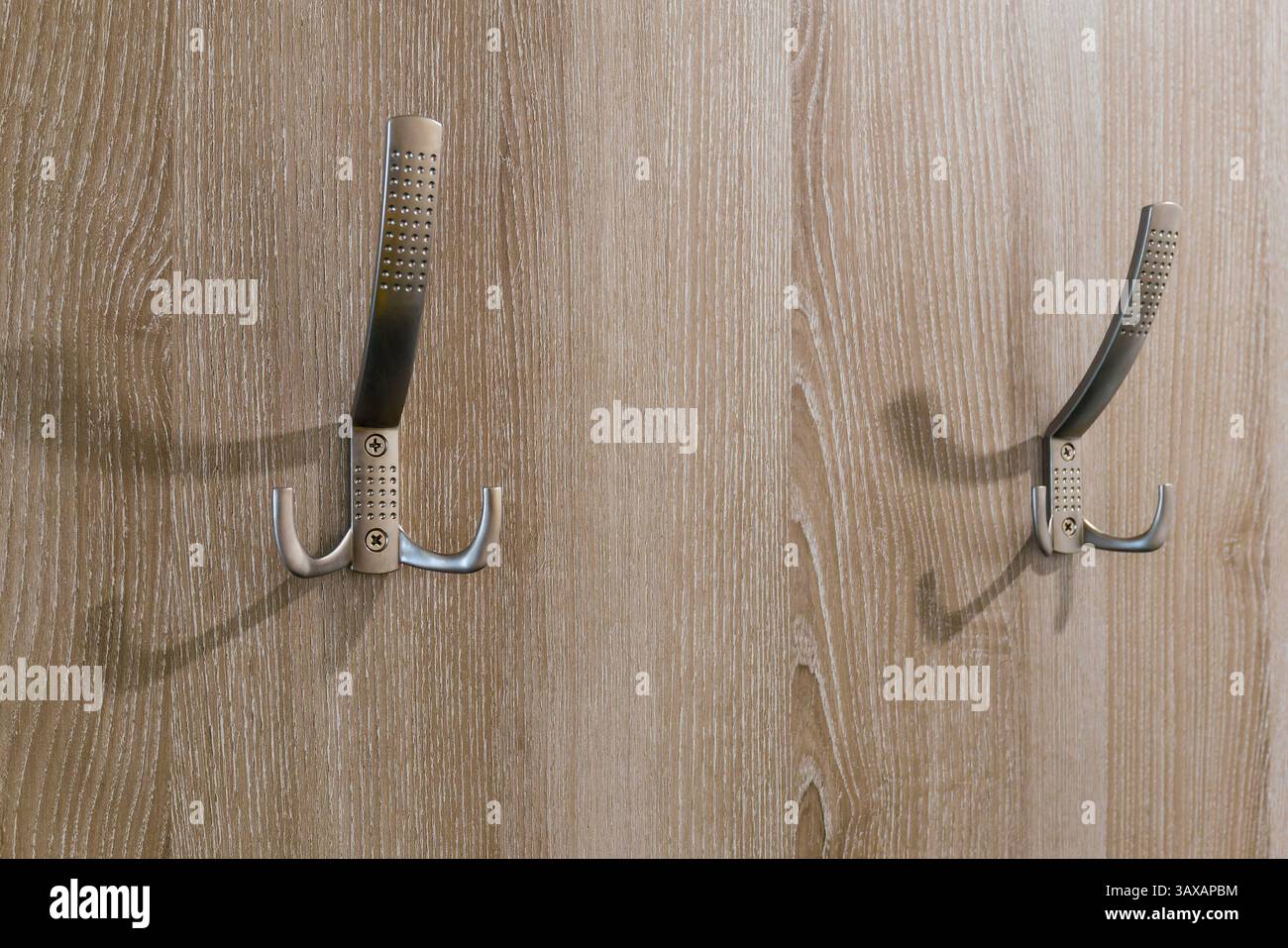 Zwei Doppelhaken auf einem Holzbügel. Stockfoto
