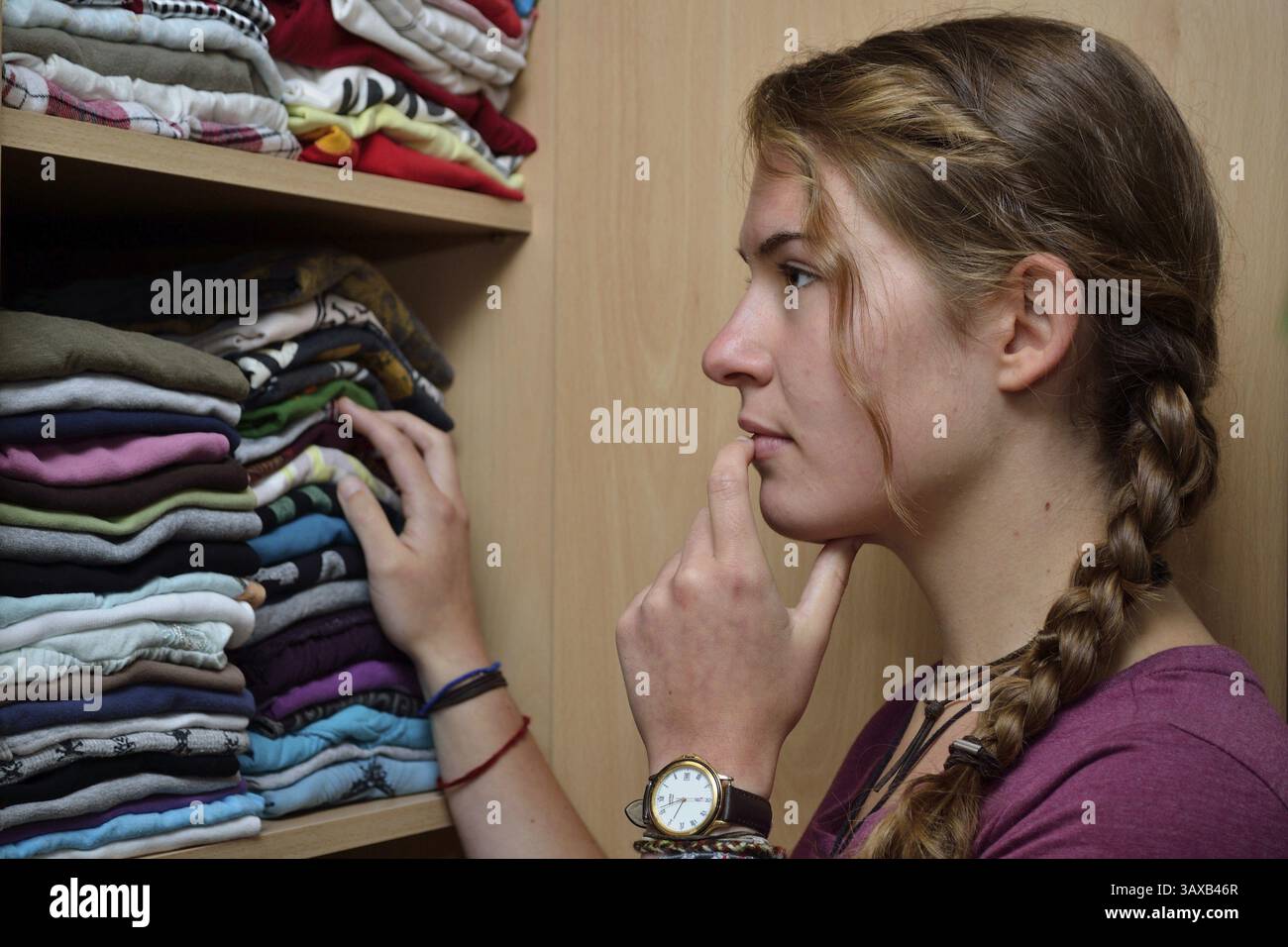 Der Teenager sucht im Kleiderschrank nach passender Kleidung Stockfoto