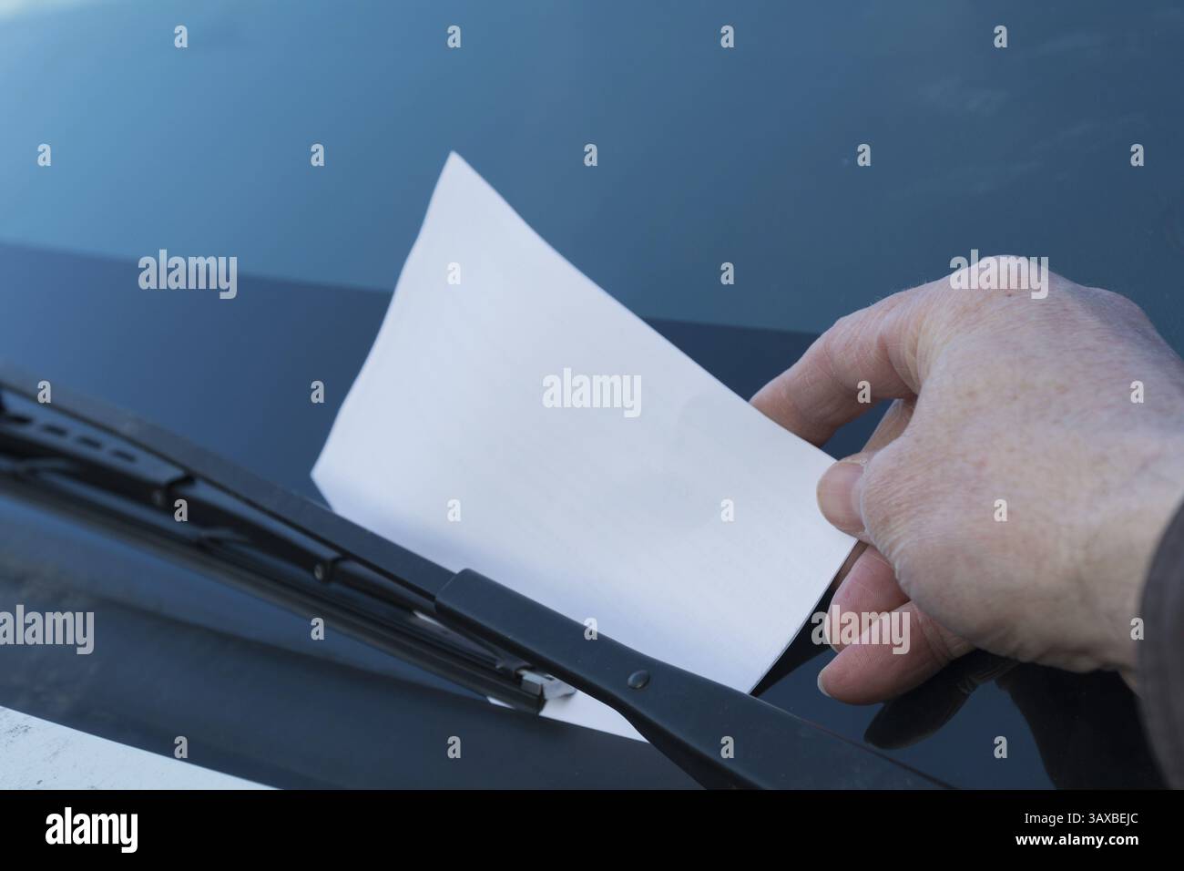 Parkwächter bringt Ticket zur Windschutzscheibe – Nahaufnahme Stockfoto