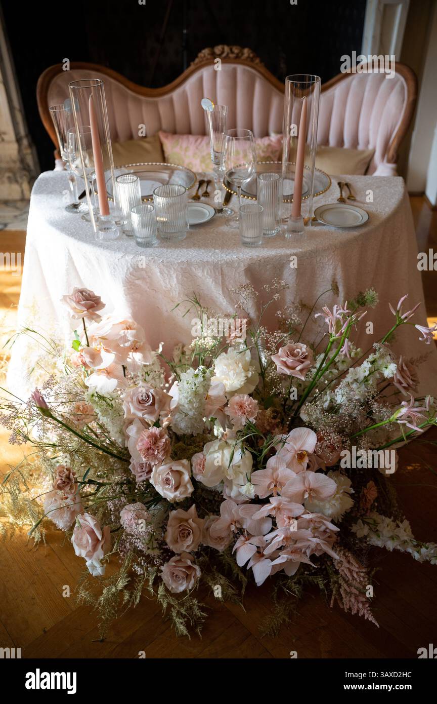 Eleganter Hochzeitstisch mit üppigem Blumenaufsatz Stockfoto