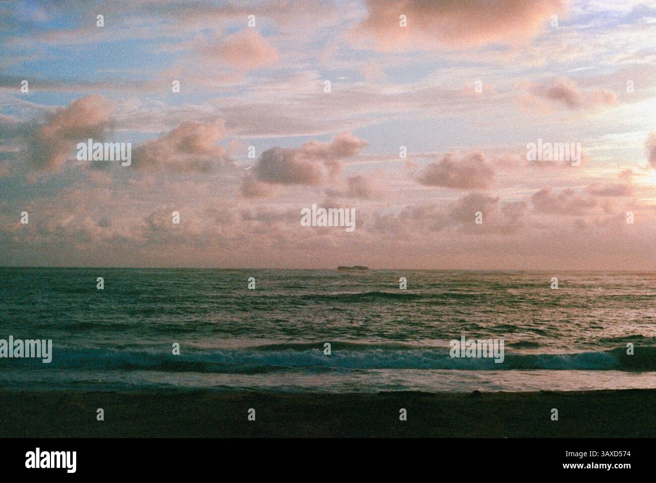Ein pastellfarbener Himmel trifft auf den Meereshorizont in einer ruhigen Meereslandschaft Stockfoto