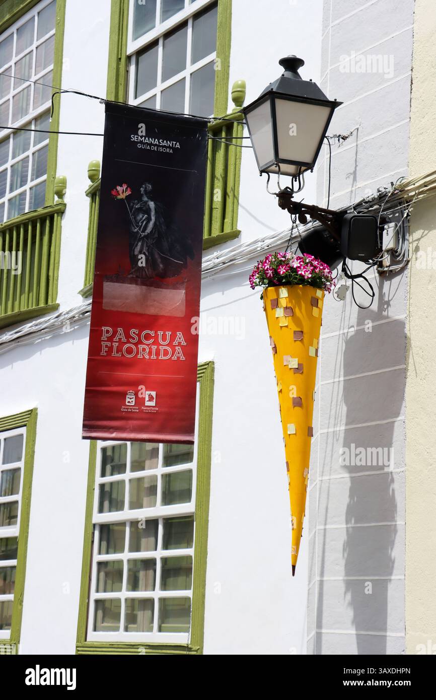 Florales Osterplakat in Guía de Isora, Teneriffa, hängt an der Fassade eines typischen kanarischen Hauses. Fusion von Blumenkunst und zeitgenössischer Straßenkunst Stockfoto