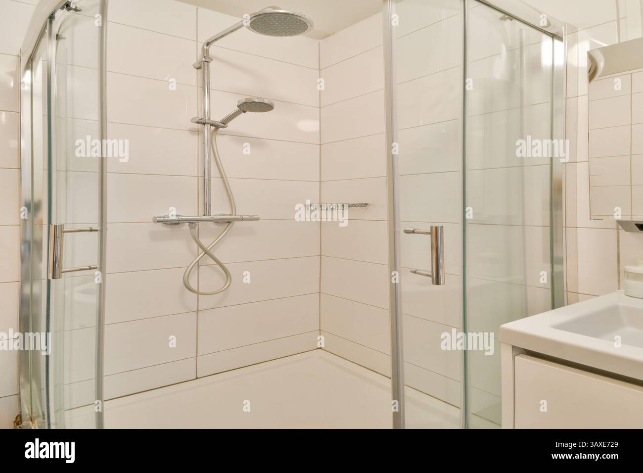 Eine moderne Duschkabine mit eleganten Glastüren und minimalistischen Designelementen, perfekt für eine stilvolle Renovierung des Badezimmers. Stockfoto