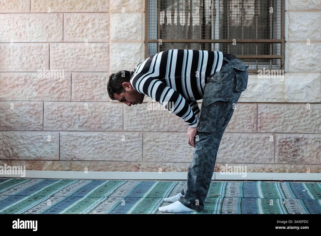 30. November 2016: Jerusalem, Israel: Ein muslimischer Mann betet vor einer von fünf Moscheen im Dorf Bet Safafa. Die israelische Regierung schlug eine Gesetzgebung vor, die religiöse Einrichtungen von der Verwendung von Außenlautsprechern, den sogenannten Muazzin Bill, verbieten sollte, wie in dem fünfmal täglich stattfindenden muslimischen Gebetsaufruf. Das Gesetz, das als Bedrohung für die muslimischen Gemeinschaften und als Schritt der israelischen Regierung zur Schließung von Moscheen bezeichnet wird, soll zur Vorababstimmung vorgelegt werden. (Bild: © Nir Alon via ZUMA Wire) Stockfoto