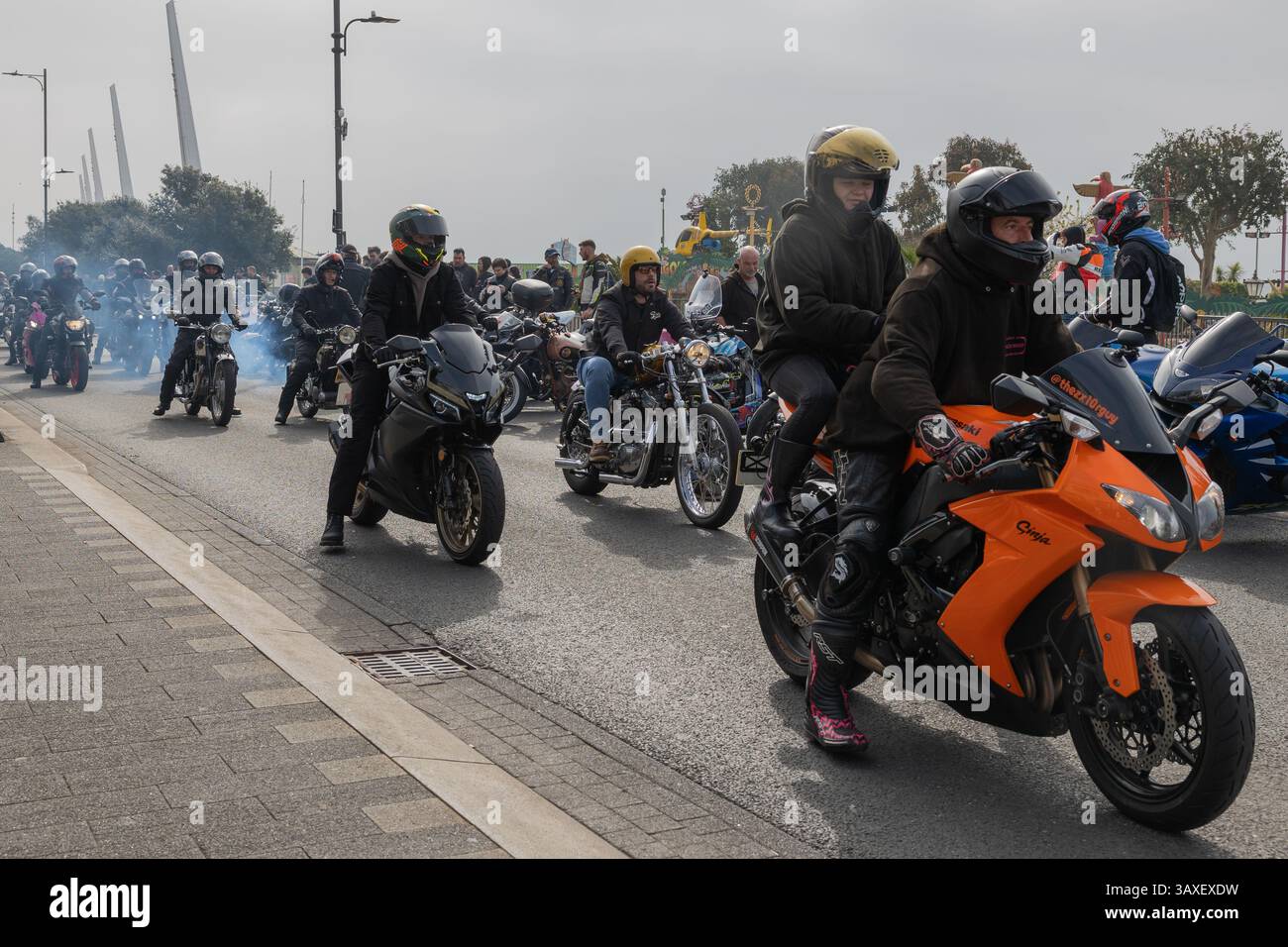 Southend on Sea, Großbritannien. April 2025. Eine große Gruppe von Motorradfahrern fährt gemeinsam durch eine Stadtstraße während einer öffentlichen Kundgebung. Die Szene zeigt Sporträder, Cruiser und Tourenmotorräder, wobei die Fahrer Helme und Schutzausrüstung tragen. Rauch im Hintergrund deutet auf Ausbrennen oder Auspuff der Reifen hin. Hunderte von Motorrädern säumen die Küste am Ende einer Fahrt vom Ace Café. Die Veranstaltung Southend Shakedown kehrt dieses Jahr nach einer zweijährigen Unterbrechung aufgrund von Finanzierungsproblemen zurück. Penelope Barritt/Alamy Live News Stockfoto