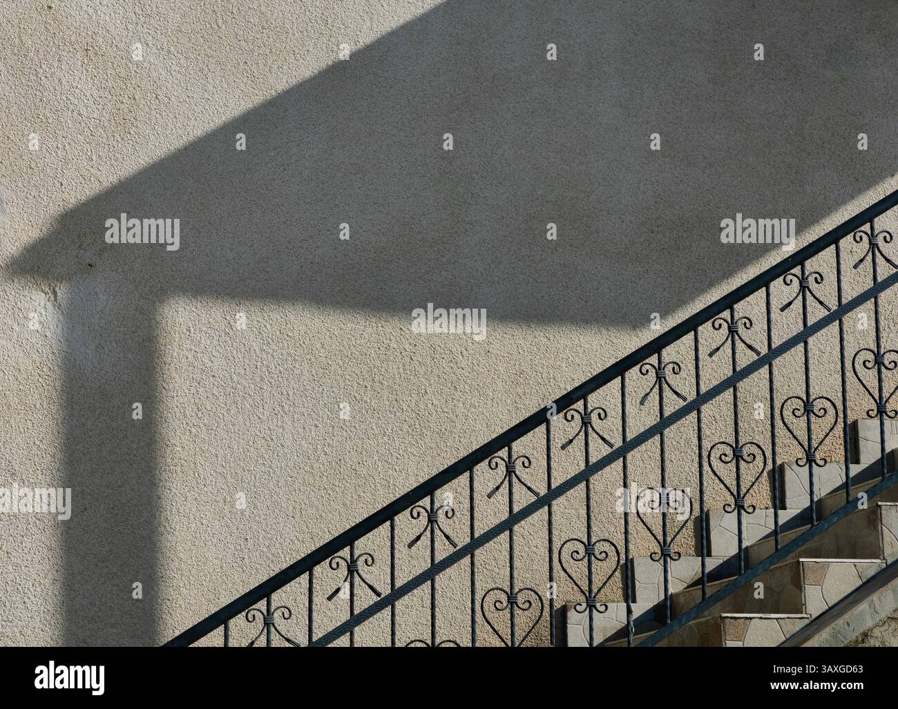 Geschmiedete Leuchte. Städtische Symmetrie. Teil der Hauswand außen, Architektur. Stockfoto