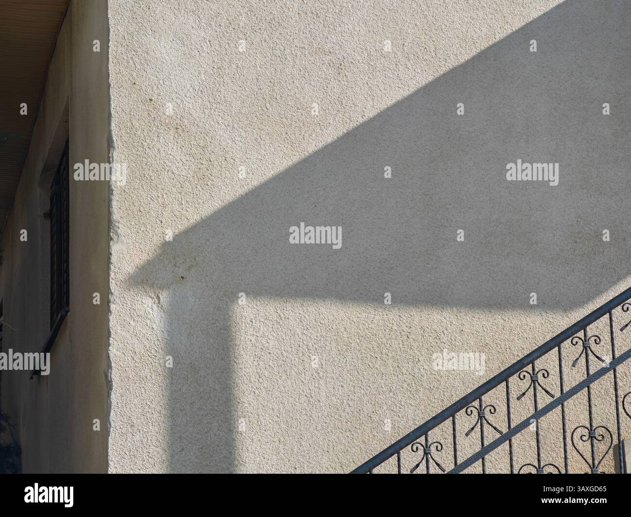 Geschmiedete Leuchte. Städtische Symmetrie. Teil der Hauswand außen, Architektur. Stockfoto