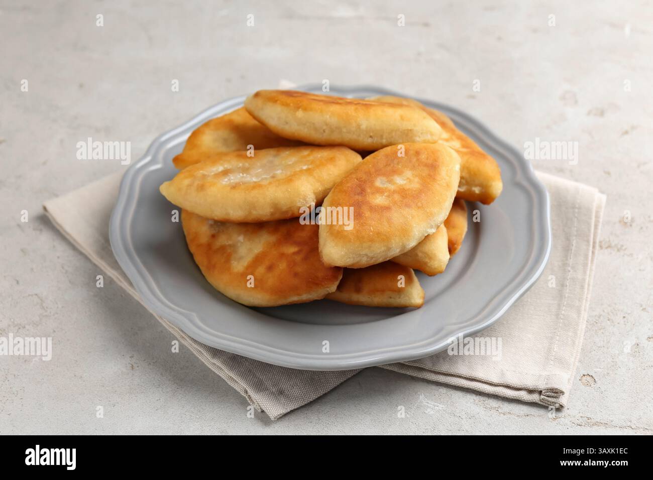 Köstliche gebratene Pyrizhky (gefüllte Kuchen) auf hellgrauem Tisch, Nahaufnahme Stockfoto Köstliche gebratene Pyrizhky (gefüllte Kuchen) auf hellgrauem Tisch, Nahaufnahme Stockfoto