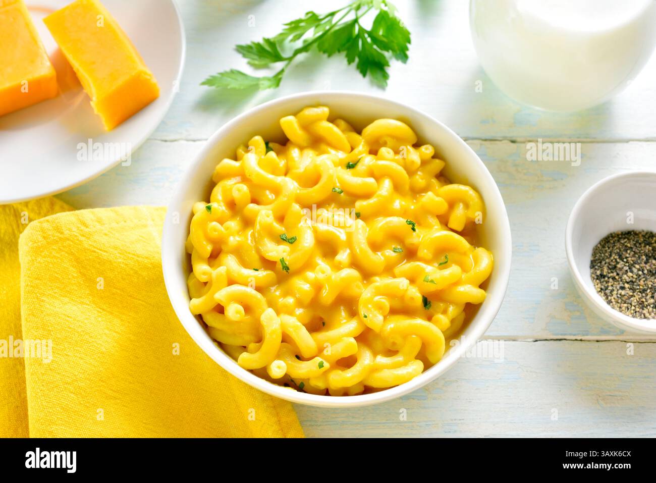 Makkaroni und Käse in der Schüssel auf hellem hölzernem Hintergrund. Nahansicht Stockfoto
