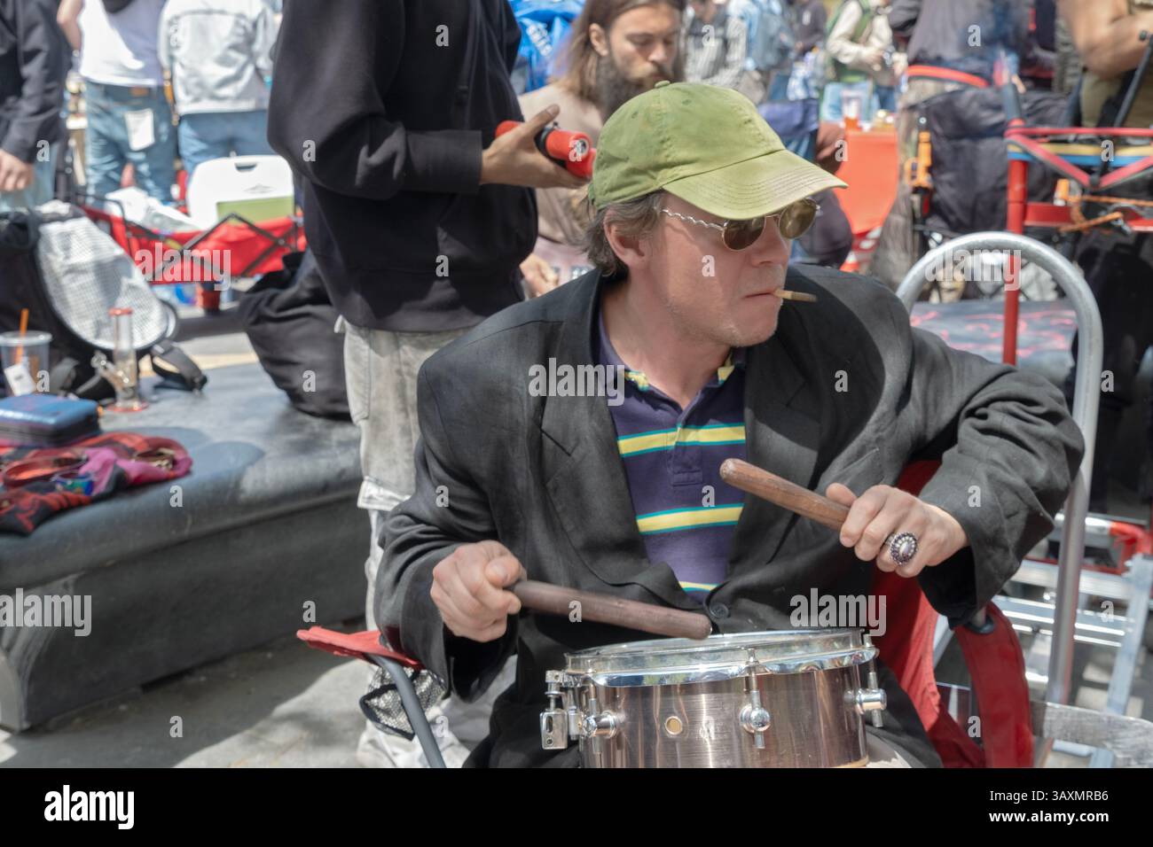 Beim 420 Pot Smoke-in in the Village im Washington Square Park in New York spielt ein Mann Schlagzeug, während er einen Joint raucht. In Manhattan, New York. Stockfoto