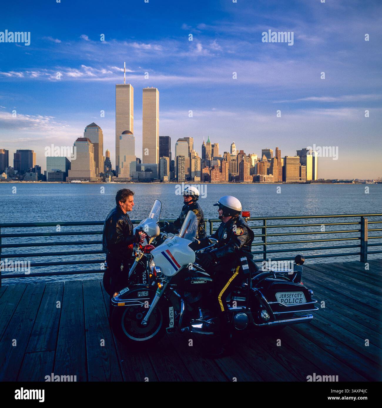 New York, Jahrgang 1990, Mann im Gespräch mit 2 motorisierten Polizeibeamten aus Jersey City, Skyline von Manhattan, Hudson River, New York City, NYC NY US USA, Stockfoto