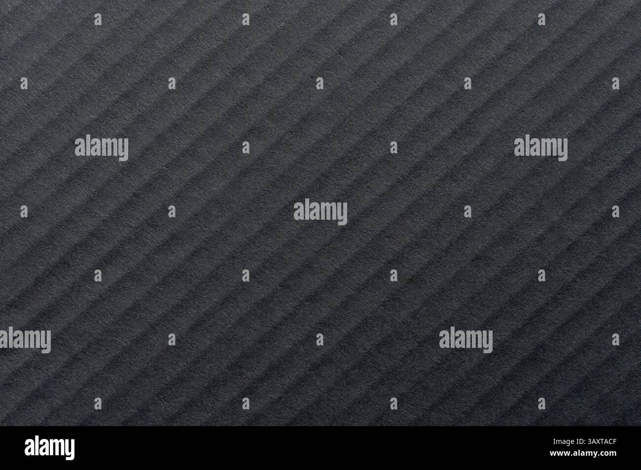 Die strukturierte Oberfläche mit diagonalen Linien bildet ein elegantes Muster unter natürlichem Licht und erzeugt Tiefe und Kontrast. Stockfoto