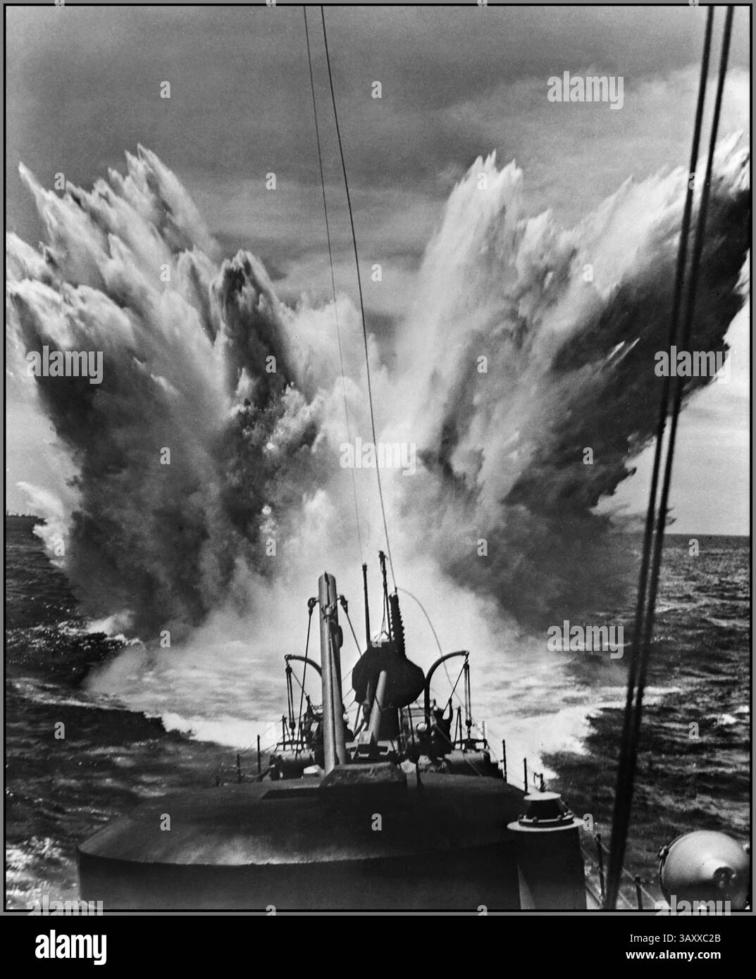 TIEFENLADUNG ATLANTISCHER Weltkrieg Nazi-U-Boot Tiefenexplosion während der Atlantikschlacht 1943. Der zweite Weltkrieg zeigt eine Tiefenladung, die in der Nähe eines Schiffes während der Atlantikschlacht im Zweiten Weltkrieg explodierte. Tiefenladungen waren Anti-U-Boot-Waffen, die verwendet wurden, um untergetauchte U-Boote anzugreifen. Tiefenladungen waren Stahlfässer mit Sprengstoff gefüllt. Sie wurden von Schiffen in der Nähe eines mutmaßlichen feindlichen U-Bootes abgesetzt oder abgeschossen. Eine Sicherung zündete die Ladung in einer voreingestellten Tiefe, wodurch ein zerstörerischer hydraulischer Druckeffekt entsteht. Stockfoto