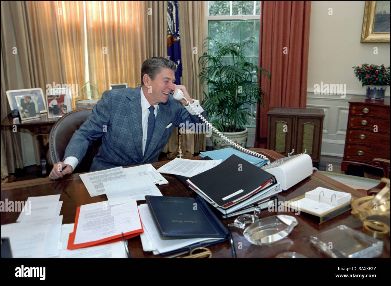 Präsident Ronald Reagan Oval Office Desk Des Weißen Hauses. (1981-1989) der Präsident telefoniert am 11. November 1982 am 11. November 1982 mit Space Shuttle im Oval Office. Im November 1982 startete das Space Shuttle Columbia seine fünfte Mission mit der Bezeichnung STS-5 und markierte damit einen wichtigen Meilenstein im Space Shuttle-Programm der NASA.​ Präsident Ronald Reagan und First Lady Nancy Reagan besuchten die Edwards Air Force Base, um Zeuge der Landung von Columbia zu sein. Diese Veranstaltung unterstrich die wachsende Bedeutung des Shuttle-Programms in den US-amerikanischen Raumfahrtforschungen.​ Stockfoto