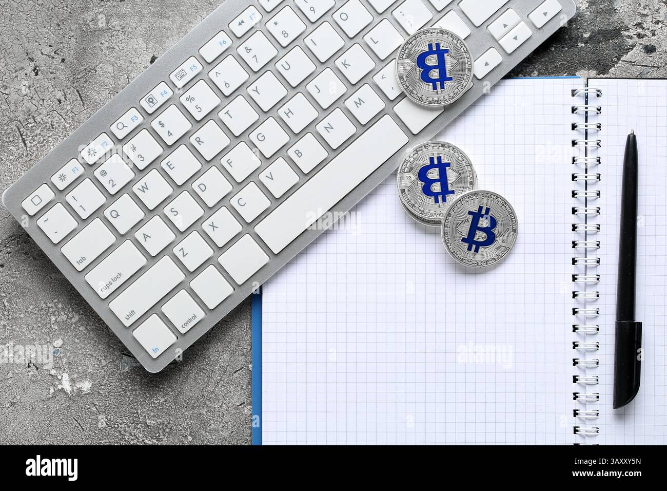 Computertastatur mit Bitcoins und Notizbuch auf Grunge-Hintergrund Stockfoto