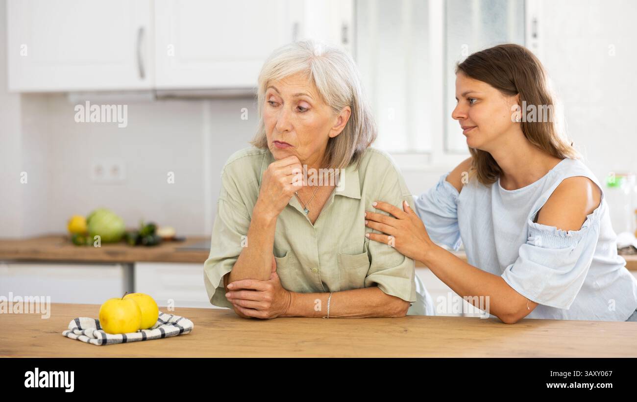 Eine Frau tröstet ihre depressive ältere Mutter Stockfoto