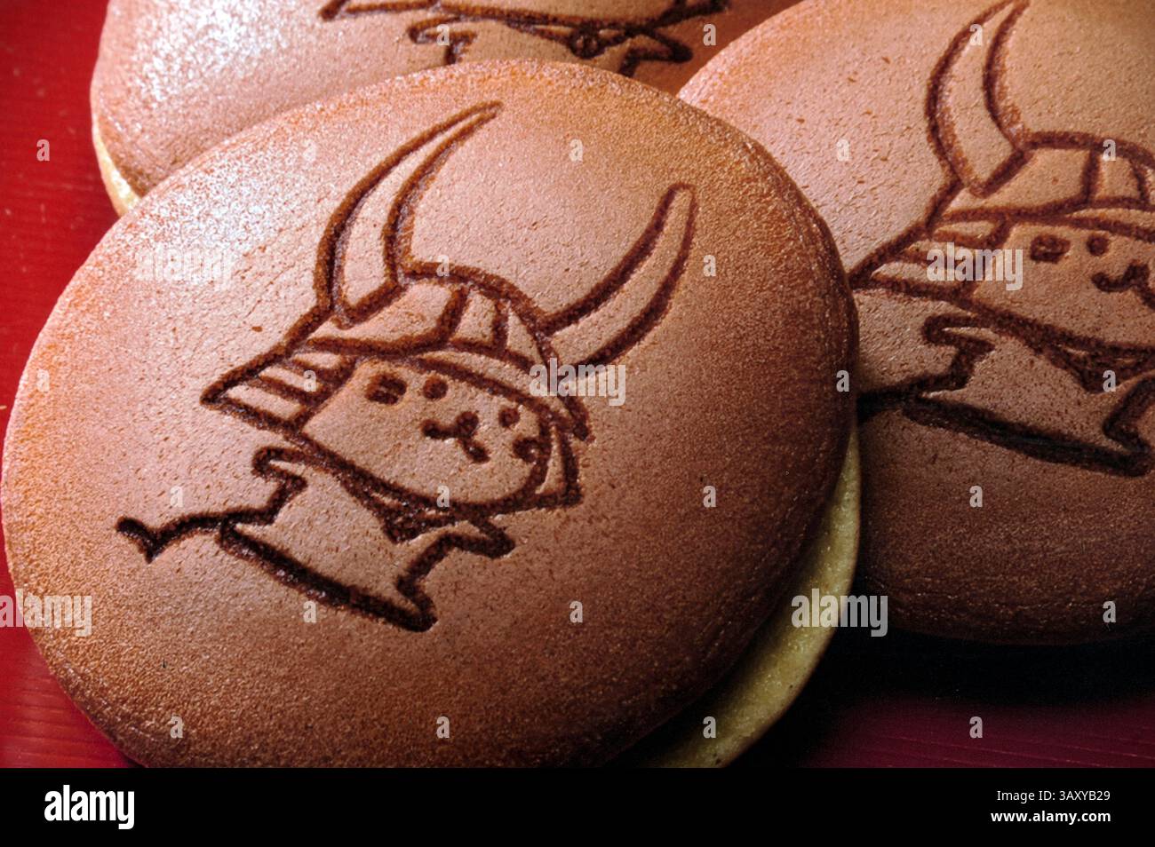 Die Hikone-Stadt kawaii yurukyara japanische Masottchen-Figur Hikonyan (Samurai-Katze) gestempelt auf frisch gebackenen Dorayaki-Bohnenpaste-Brötchen zum Verkauf in Japan. Stockfoto