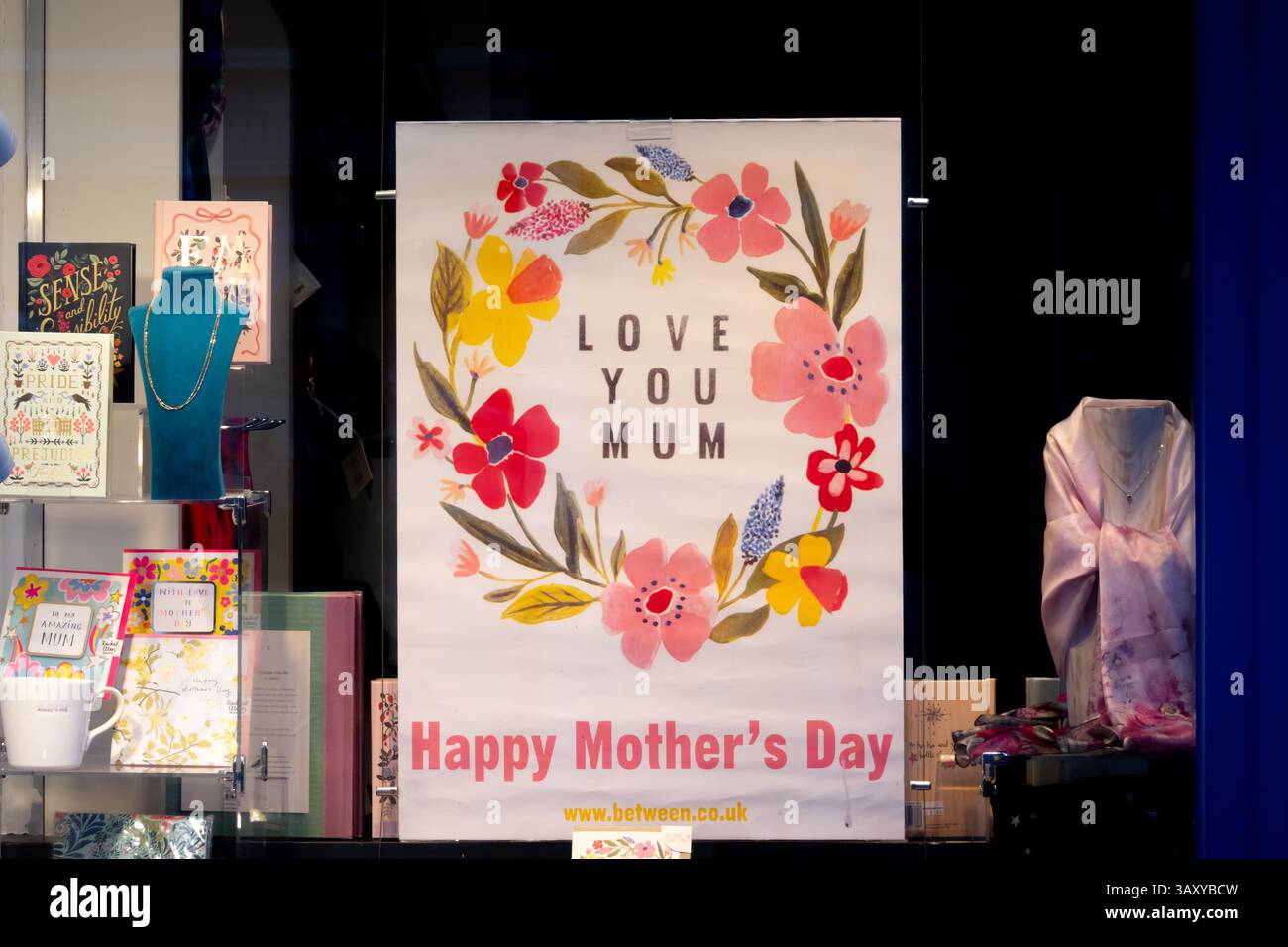 Ein Schaufenster in Saffron Walden zeigt eine Muttertagsbotschaft mit Blumenmotiven, Ketten und Karten. Diese Szene verkörpert perfekt eine Besonderheit Stockfoto