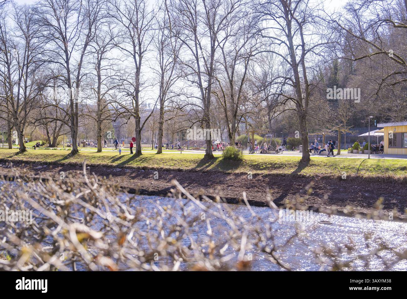 Ruhiger Flusslauf mit Spaziergängern im Park entlang einer baumgesäumten Landschaft, Nagold, Schwarzwald, Deutschland, Europa Stockfoto