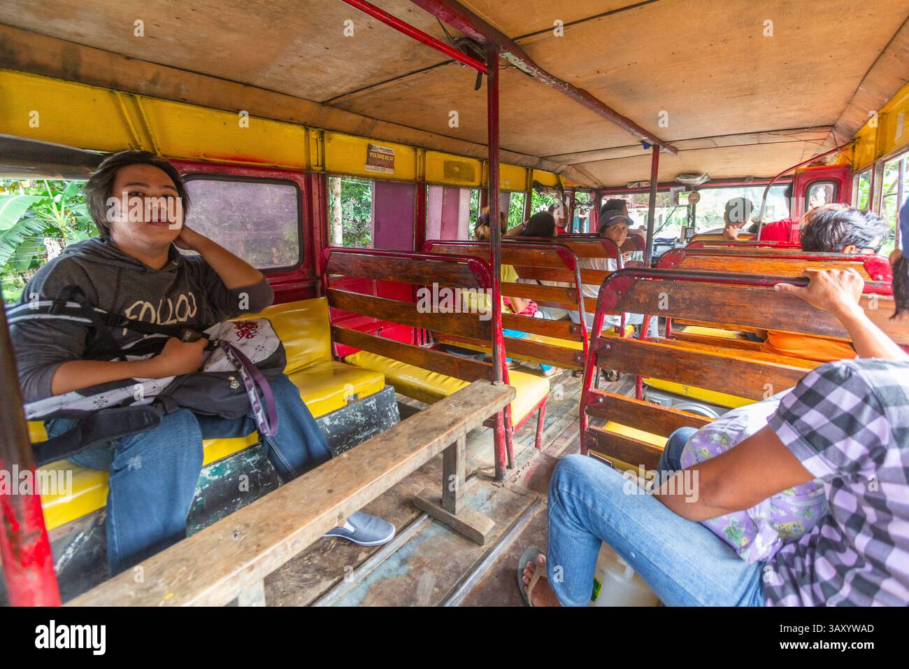 Einige Passagiere fahren in Aklan, Philippinen, in einem kleinen lokalen, nicht klimatisierten Bus entlang einer Provinzroute, in dem täglich philippinische öffentliche Verkehrsmittel gezeigt werden Stockfoto Einige Passagiere fahren in Aklan, Philippinen, in einem kleinen lokalen, nicht klimatisierten Bus entlang einer Provinzroute, in dem täglich philippinische öffentliche Verkehrsmittel gezeigt werden Stockfoto