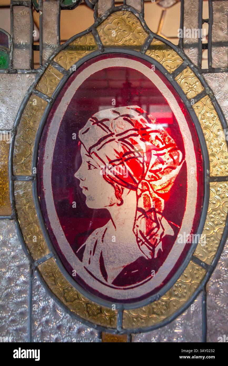 Buntglasdetail, das eine philippinische Frau in traditioneller Kleidung in einem alten, denkmalgeschützten Haus in Malabon, Metro Manila, Philippinen zeigt Stockfoto