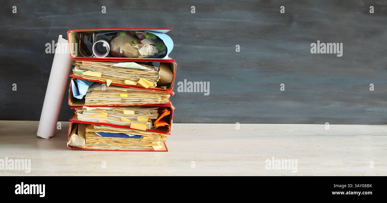 Unordentliche Aktenordner und Geschäftsunterlagen, Buraukratie, mentaler Burnout, Bürokratie, schlagen das Cloxk-Konzept. Negatives Leerzeichen mit freiem Kopierbereich. Stockfoto