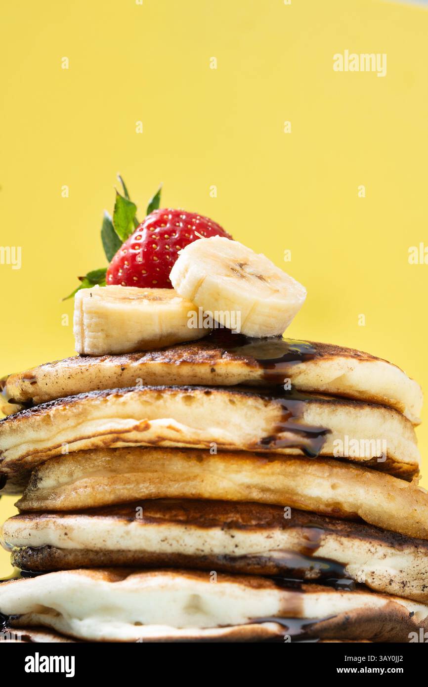 Pfannkuchen mit Schokolade, Erdbeere und Banane auf gelbem Hintergrund Stockfoto