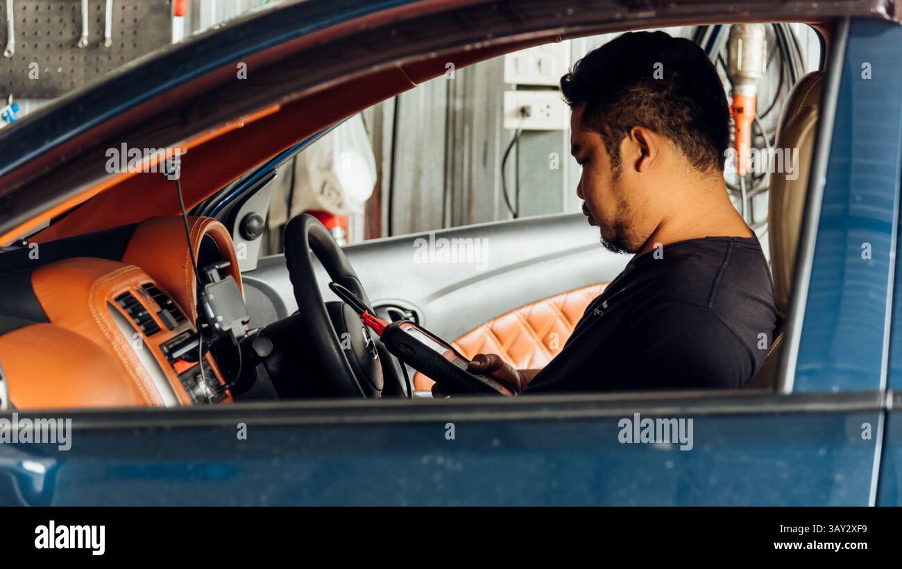 Bangkok, Thailand - 5. Mai 2017 : unbekannter Automechaniker oder Servicemitarbeiter, der einen Fahrzeugmotor mit OBD-II Elektrowerkzeugen auf Behebung und Reparatur eines Problems überprüft Stockfoto